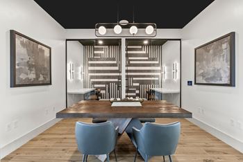 A modern dining room with a wooden table and blue chairs.
